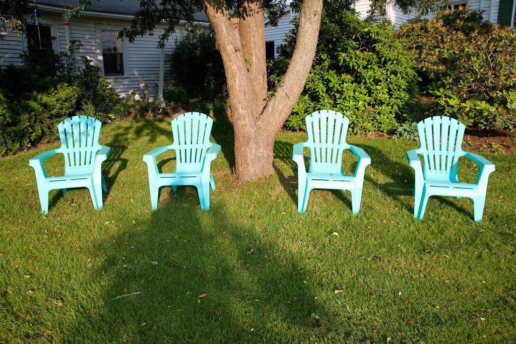 Detail of Turquois lawn chairs and green grass at sunset by Anonymous