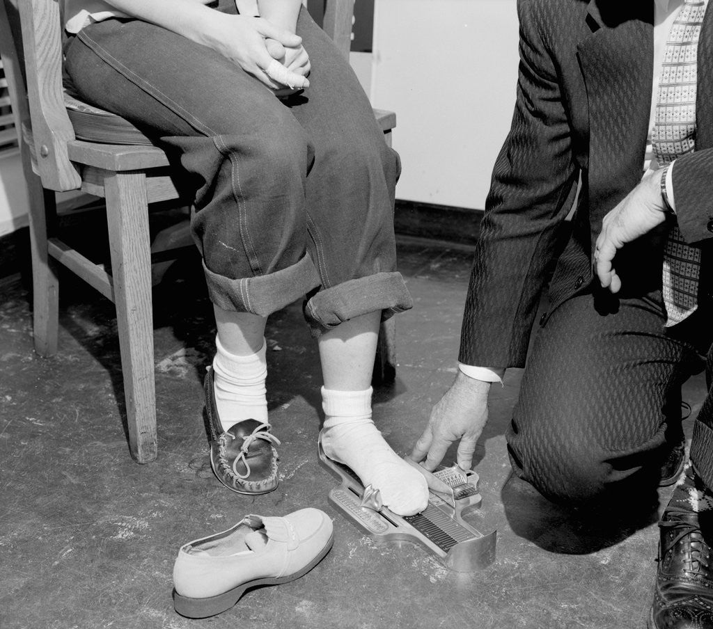 Detail of Salesmen helps woman with safety work shoes, ca. 1943 by Anonymous