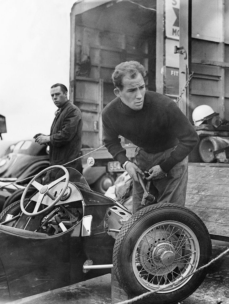 Detail of Stirling Moss maintains his car at the British Grand Prix by Associated Newspapers