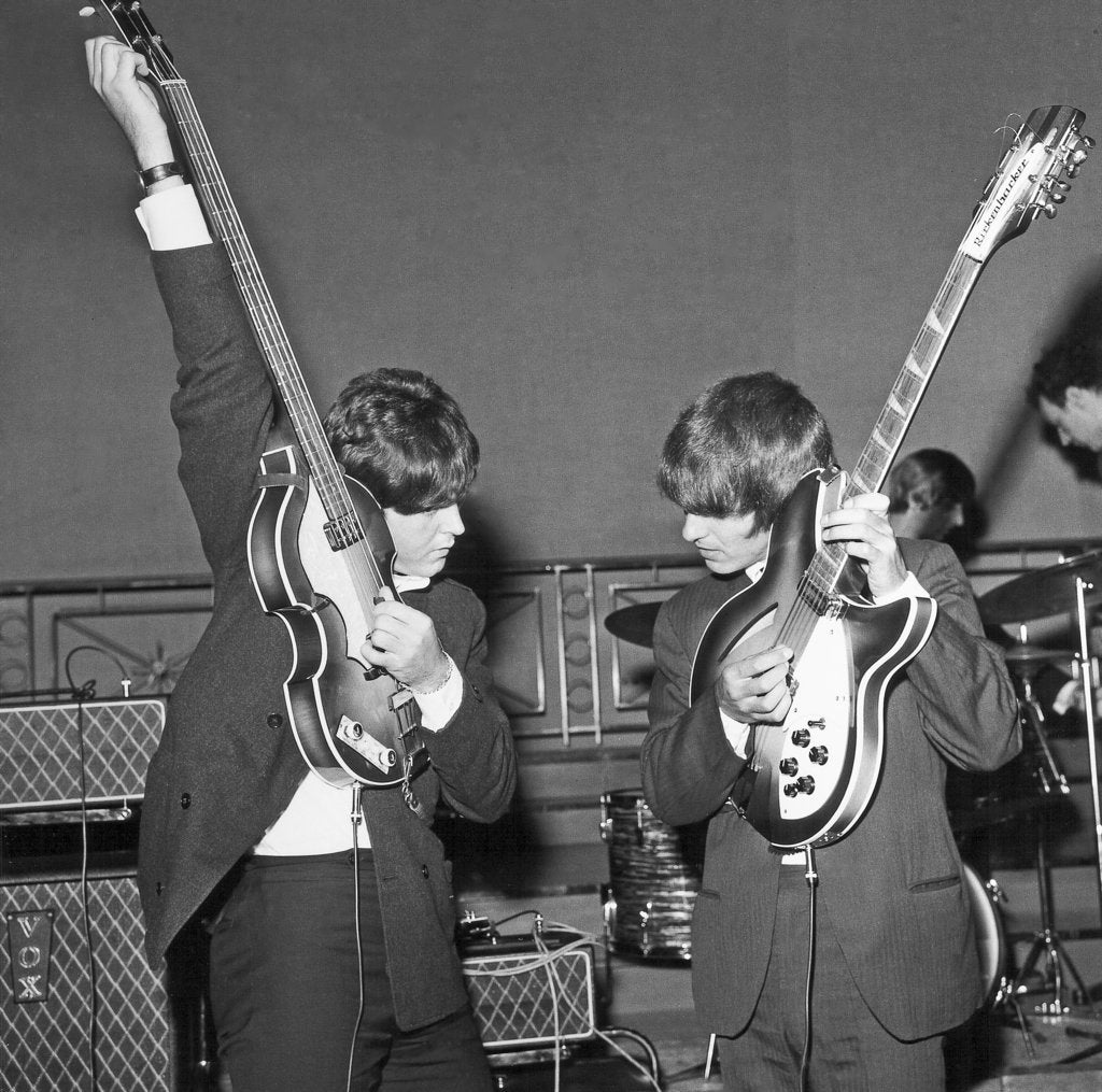 Detail of Paul McCartney and George Harrison tune their guitars by Associated Newspapers