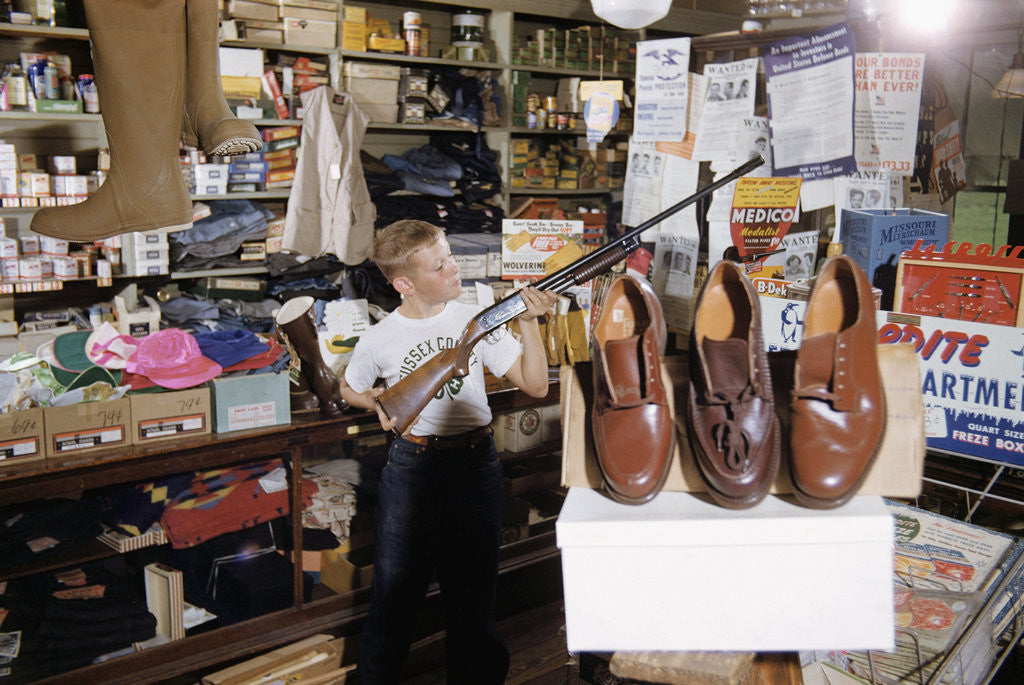 Detail of Boy Holding Shotgun in Sporting Goods Store by Corbis