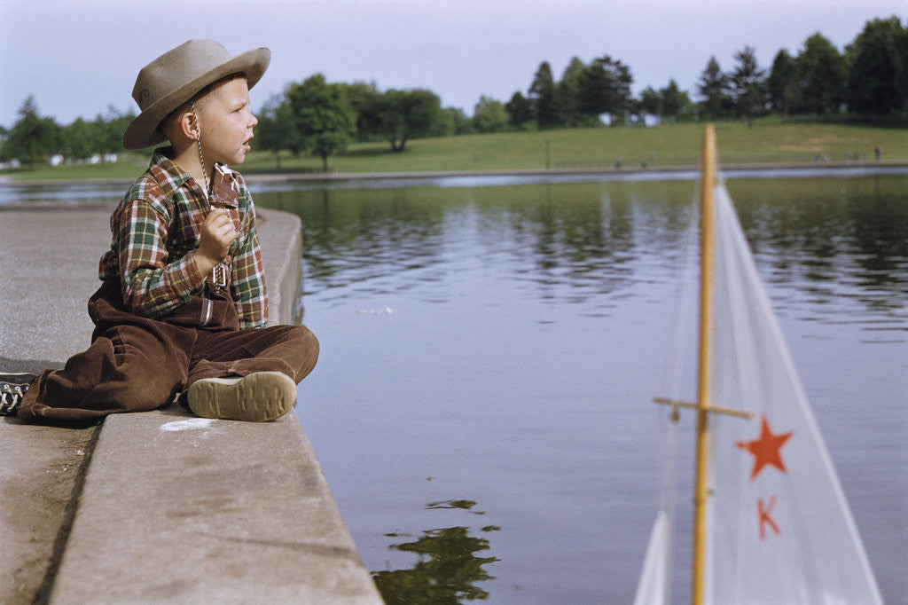Detail of Boy Sitting by Lake in Cowboy Hat by Anonymous