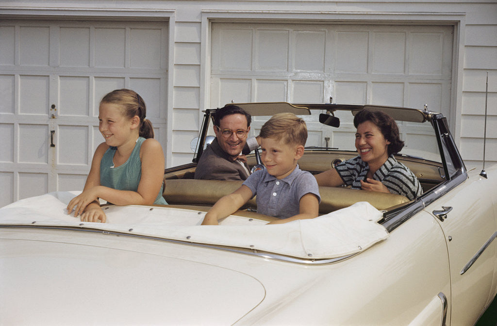 Detail of Family Sitting in Car Outside Garage by Anonymous