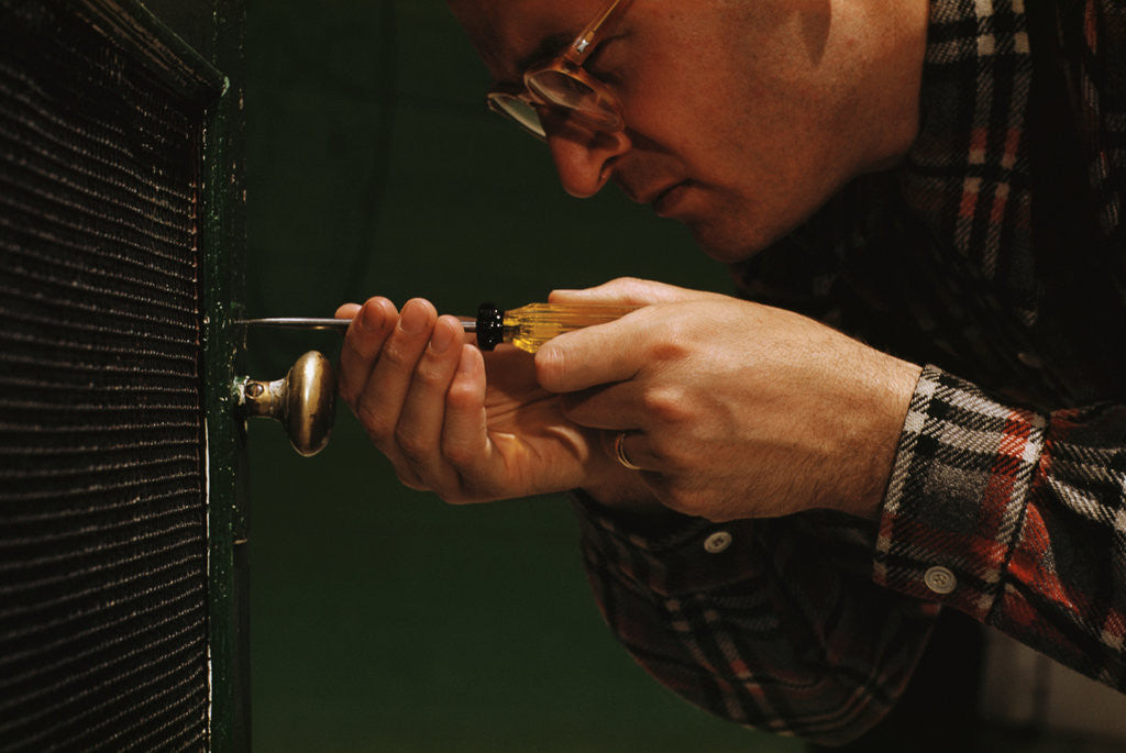 Detail of Man Fixing Knob on Screen Door by Corbis