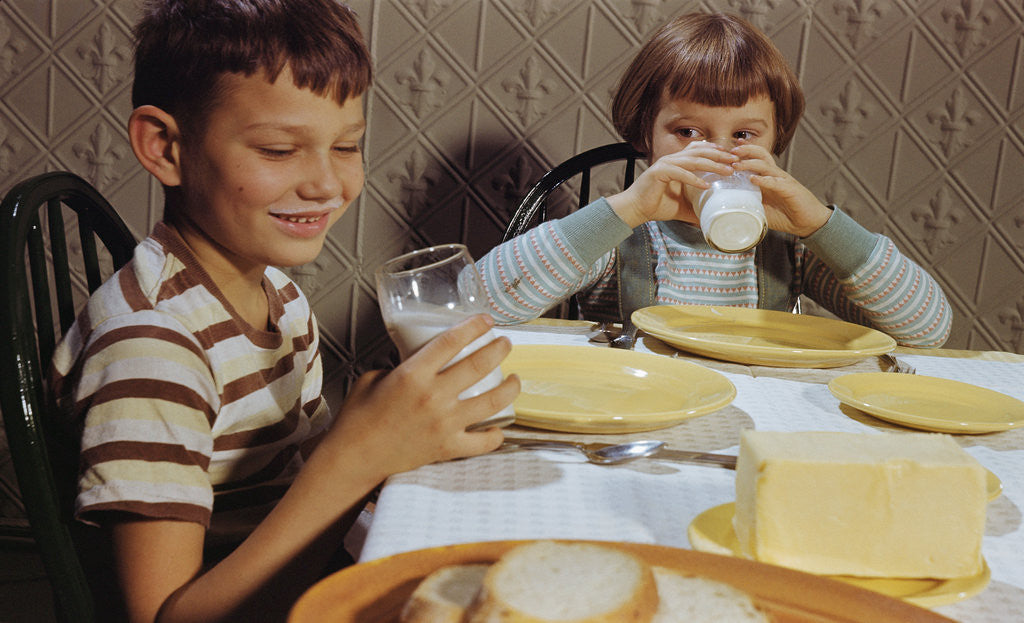 Detail of Children Drinking Milk at Dinner Table by Corbis
