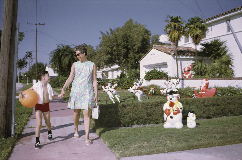 Detail of Mother and Son Walking by Christmas Decorations on Yards by Anonymous