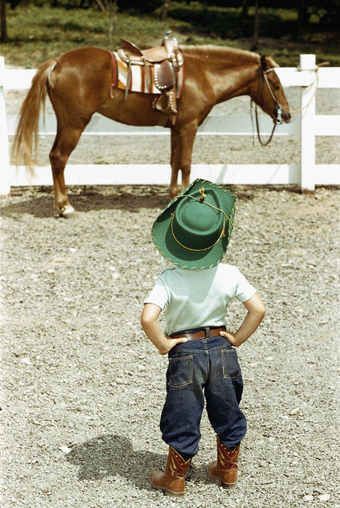 Detail of Young Cowboy Looking at Horse by Corbis
