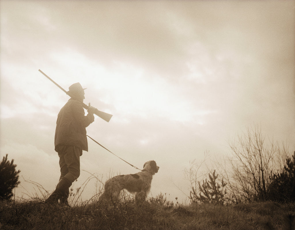 Detail of Silhouette of Hunter with Bird Dog Under Clouds by Anonymous