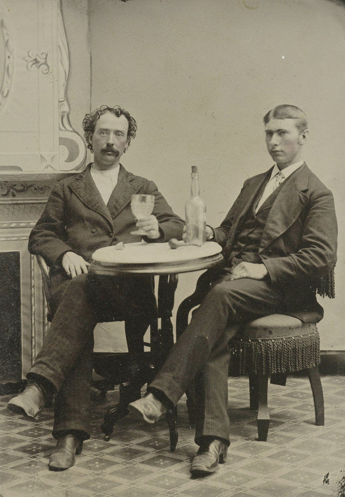 Detail of Portrait of two men sitting at the table in a studio, with a bottle and a glass, an imitation salon decor by Anonymous