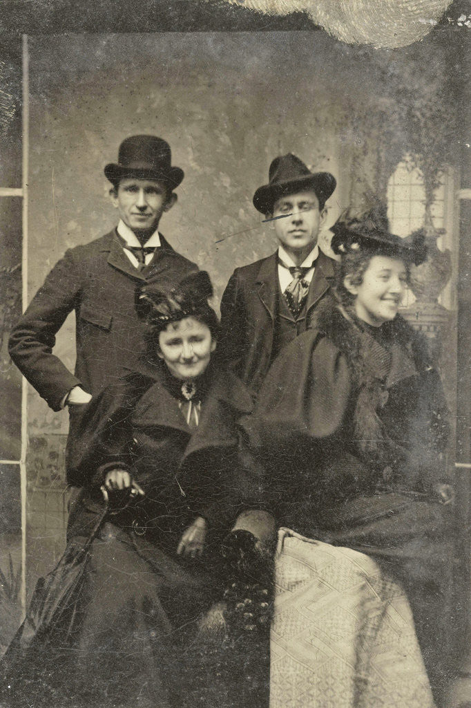 Detail of Portrait of two men and two women, one of whom looks away laughing, standing and sitting in front of a painted backdrop by Anonymous
