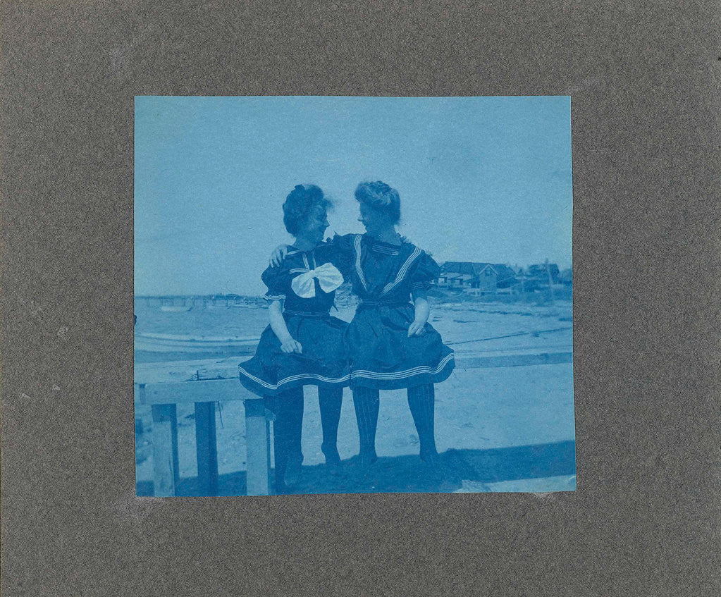 Detail of Two young women sitting on a fence on the beach, United States, USA by Anonymous