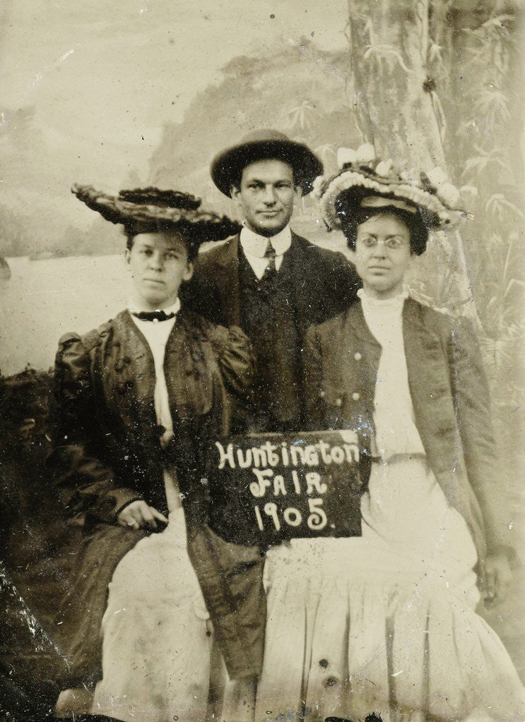 Detail of Portrait of a man and two women in front of a painted backdrop (tree, lake and mountains) and a sign that read 'Huntington FAIR 1905 by Anonymous