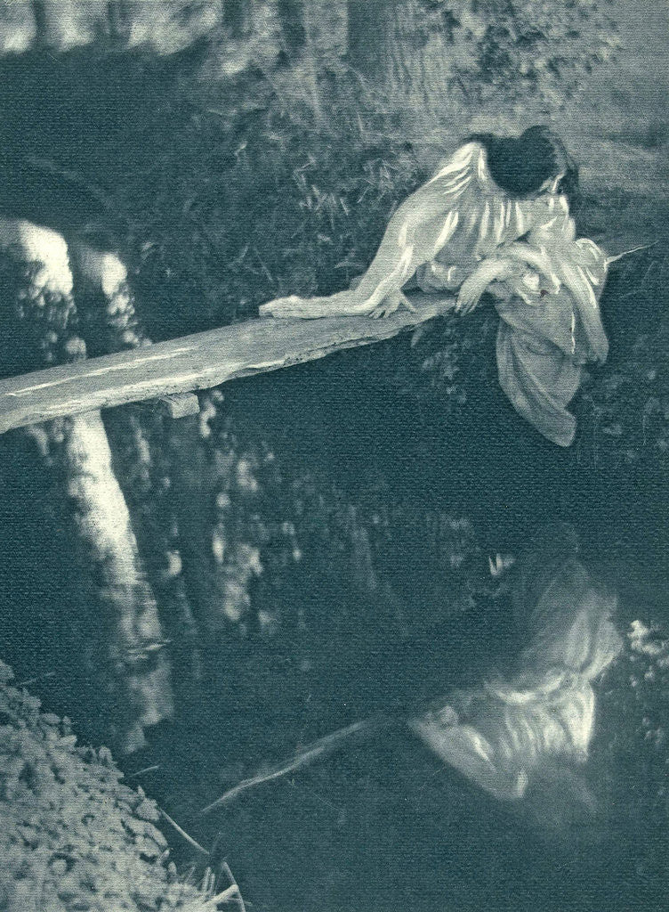 Detail of Woman sitting on a log above the water by C. Puyo