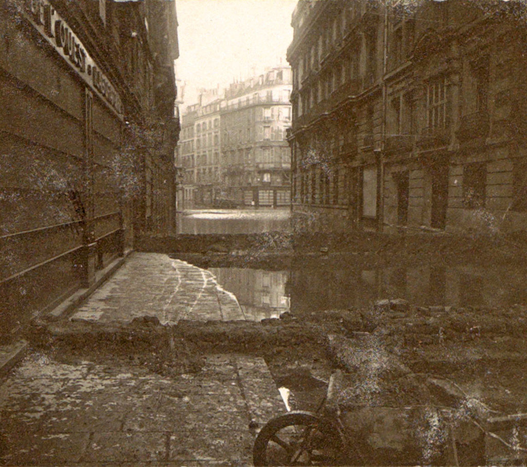 Detail of Flooded street with dams and a wheelbarrow by Anonymous