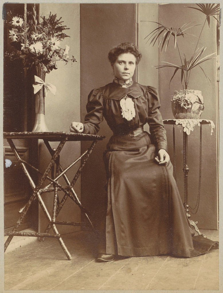 Detail of Woman sitting in a greenhouse at tables with flowers and plants by Anonymous