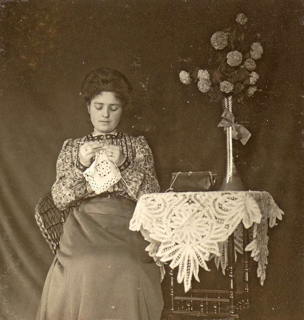Detail of Female working at a table with tablecloth and flowers by Anonymous