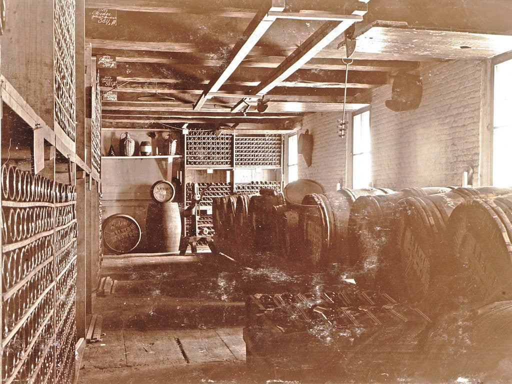 Detail of Interior of a brewery: wooden barrels and bottles on shelves by Anonymous