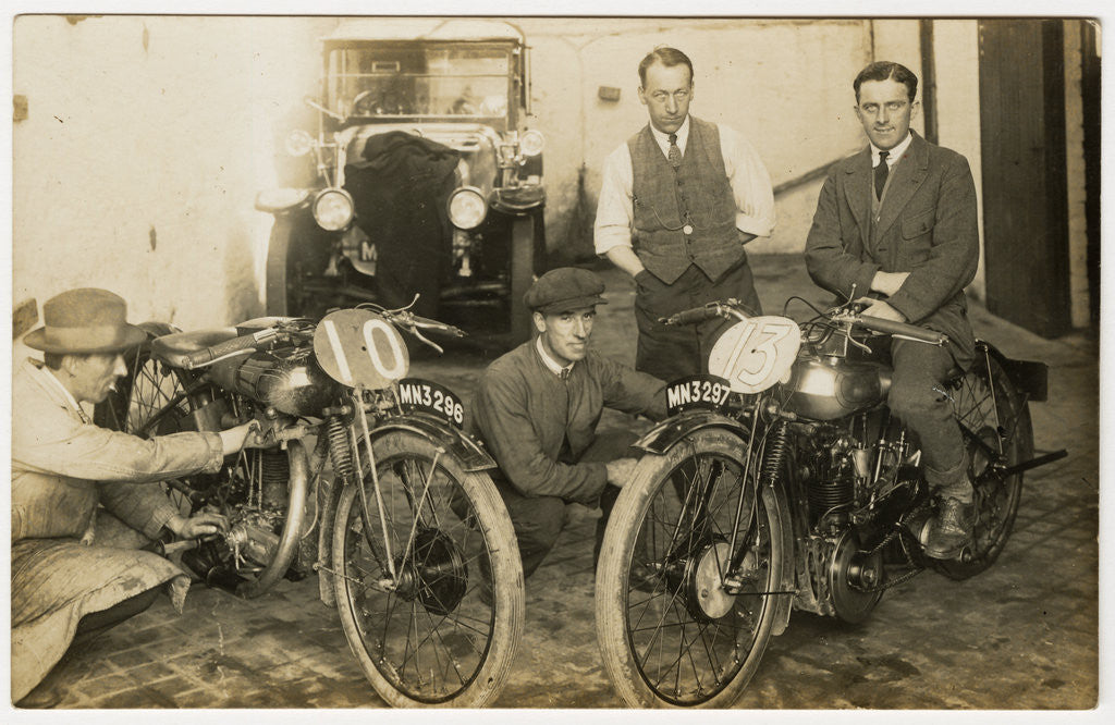Detail of Tom Sheard, TT (Tourist Trophy) rider poses with machine number 13 (registration MN3297) in a garage with mechanics by Thomas Horsfell Midwood