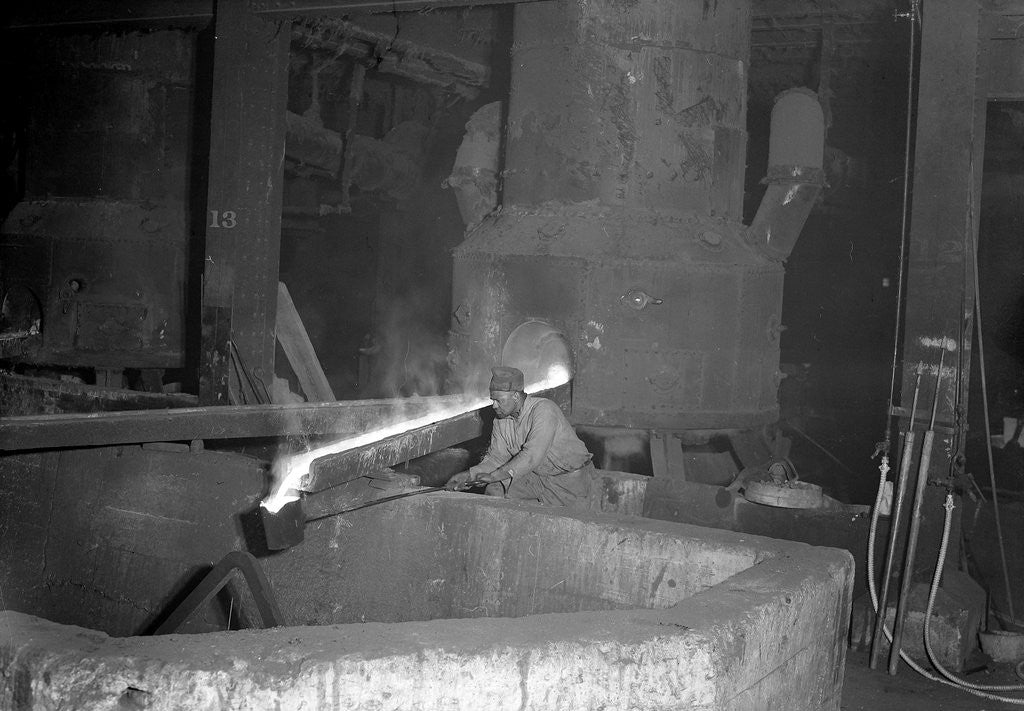 Detail of Eddystone, Pennsylvania - Railroad parts. Moulder takes a small pot of metal from tapped furnace to use on a small job, 1936 by Lewis Hine