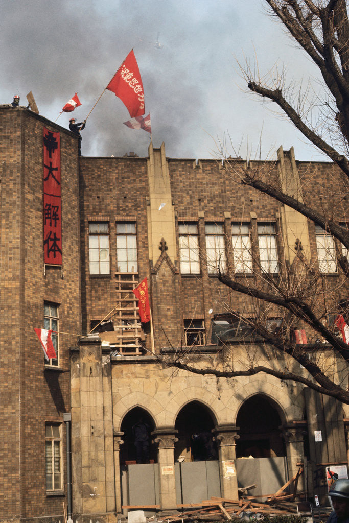 Detail of Student Waving Flag from Top of Building by Corbis