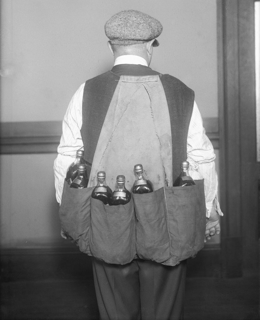 Detail of Man Wearing Coat Holding Bottles by Corbis