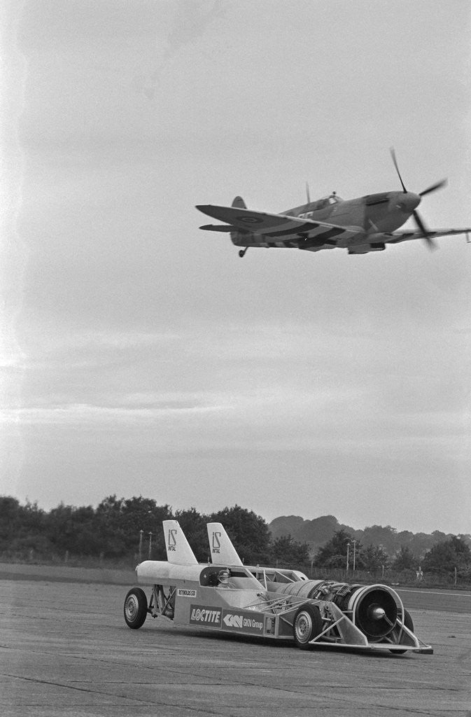Detail of Airplane Flying Over Race Car in Action by Anonymous