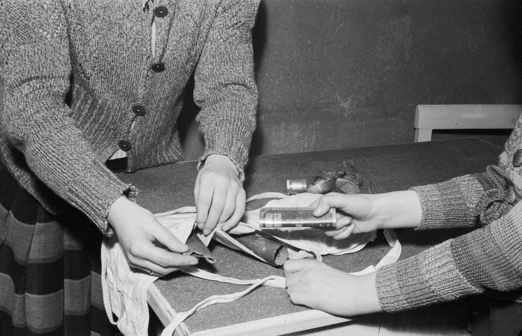 Detail of Women Placing Metal Scraps Into a Brassiere by Anonymous