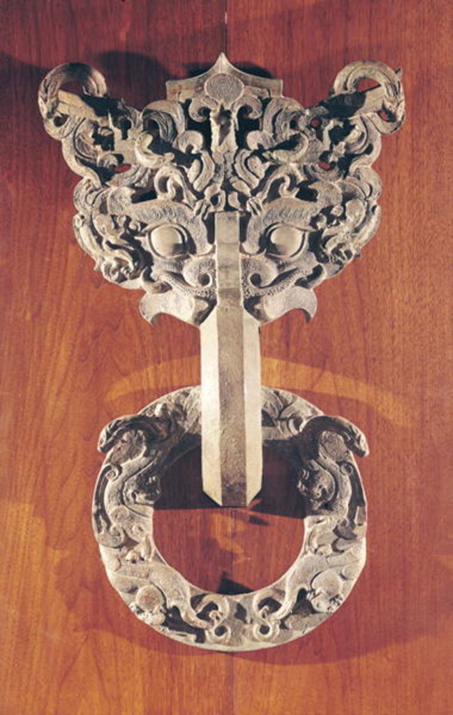 Detail of Pu shou' door knocker with a taotie design surmounted by a phoenix and holding a ring with sculpted animals by Chinese School